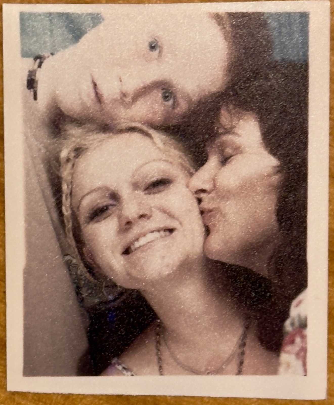 Alysha smiling, kissed on the cheek by a loved one